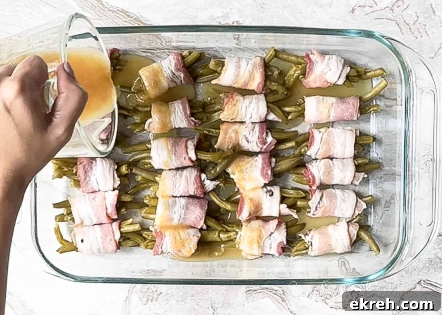 Brown Sugar Bacon Wrapped Green Bean Bundles Recipe 9 pouring butter brown sugar mixture over the rolled green bean bundles before baking.