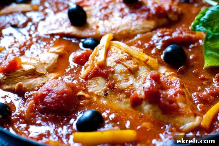 One Pan Chicken Cacciatore with Tomatoes and Olives 3 Close up of easy chicken cacciatore in a tomato sauce with peppers, olives, and onions.