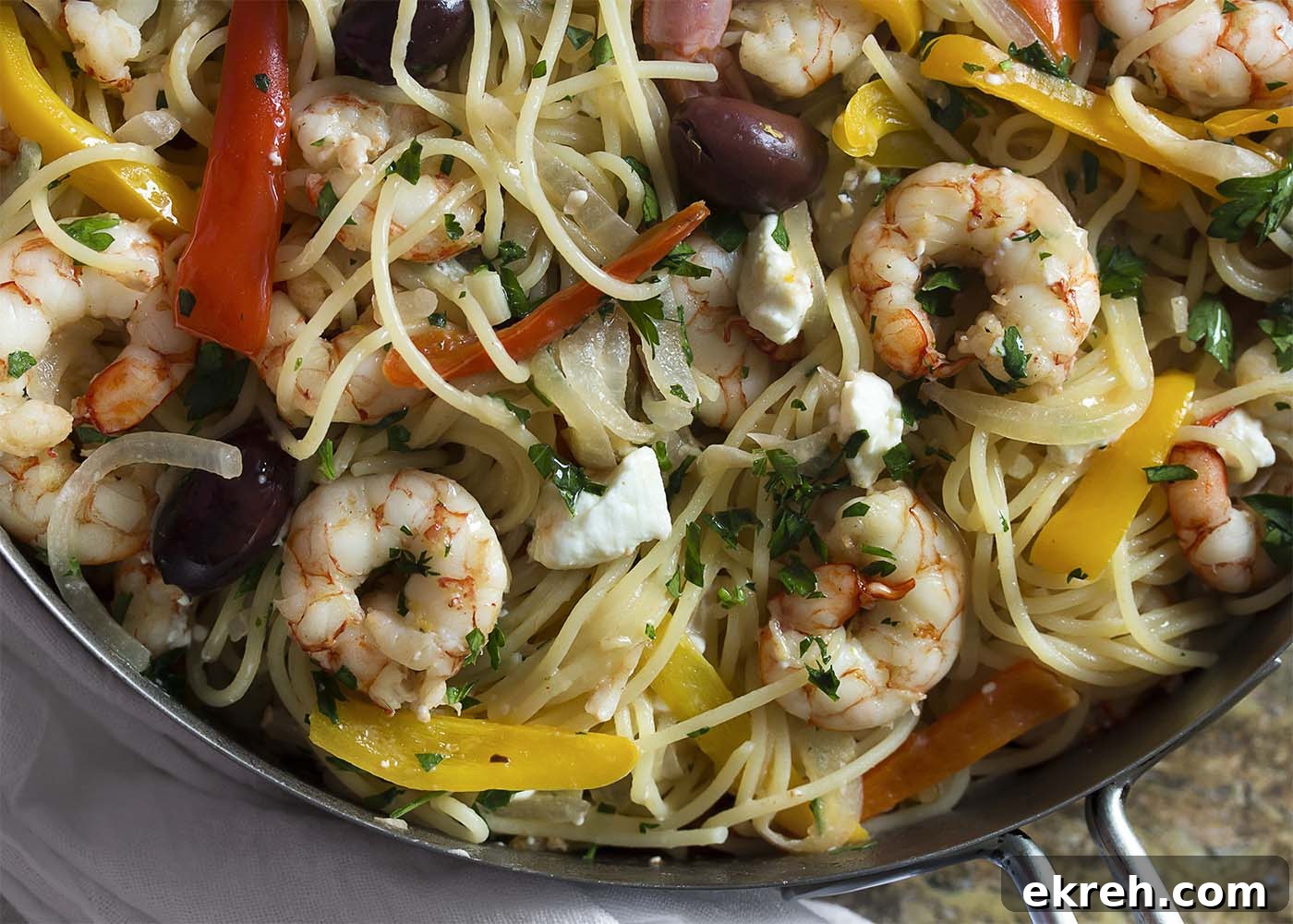 Top down view of the shrimp and pasta in a large saute pan.
