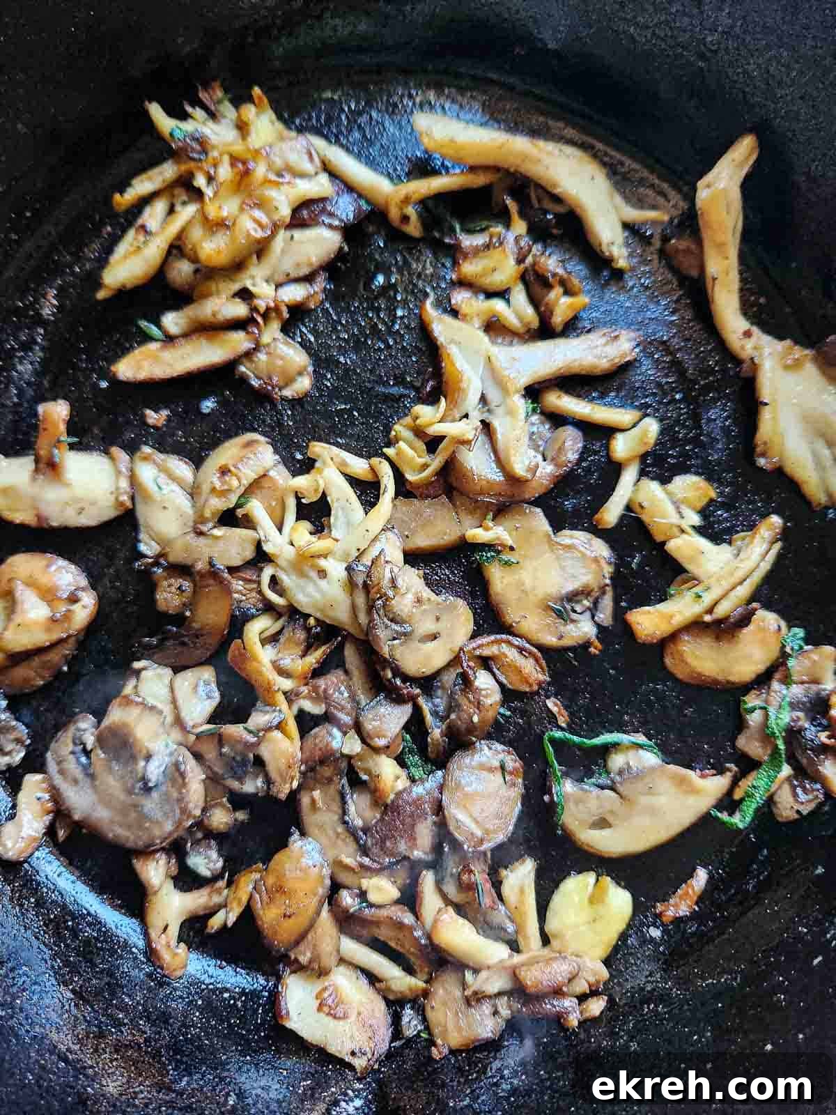 Overhead of sautéed mushrooms in a black skillet.