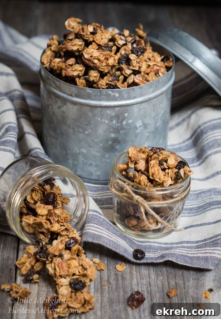A metal tin filled with Vanilla Nut Granola sitting on a blue striped towel.