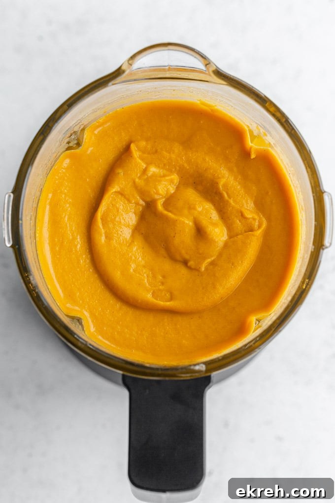 Creamy Roasted Sweet Potato and Carrot Soup Recipe 5 Overhead view of sweet potato carrot soup puréed in a blender jar.