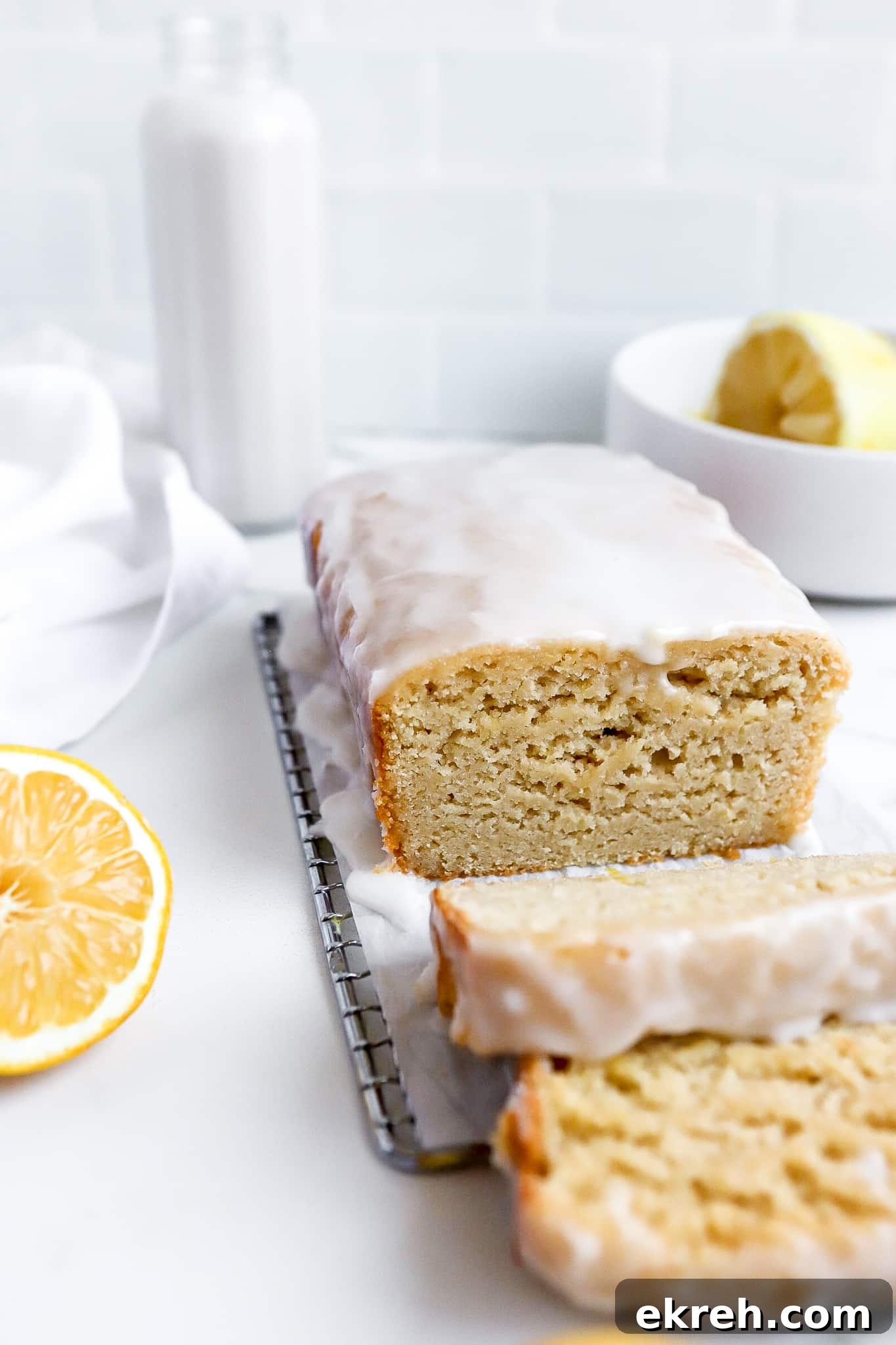 copycat starbucks lemon loaf with lemon wedges and a glass of milk in background