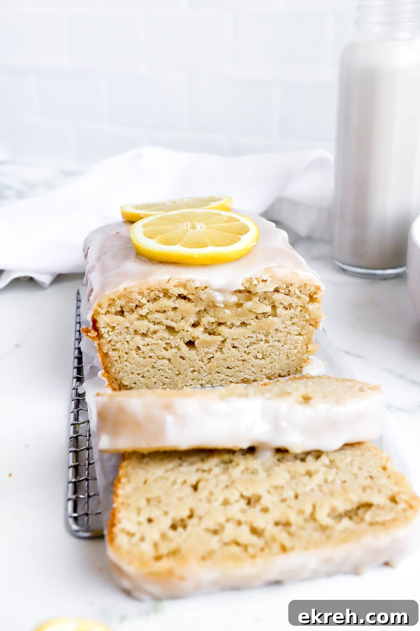front view of delicious vegan lemon loaf recipe with glass of milk in background